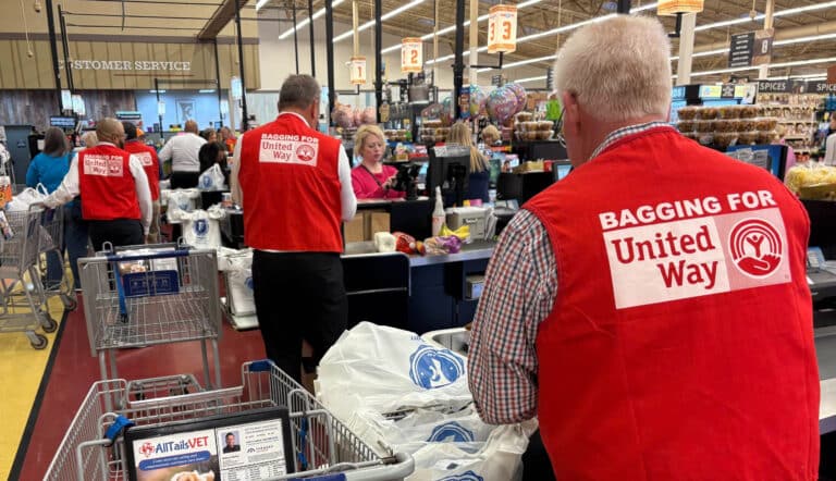 Interior store view of volunteers bagging groceries.